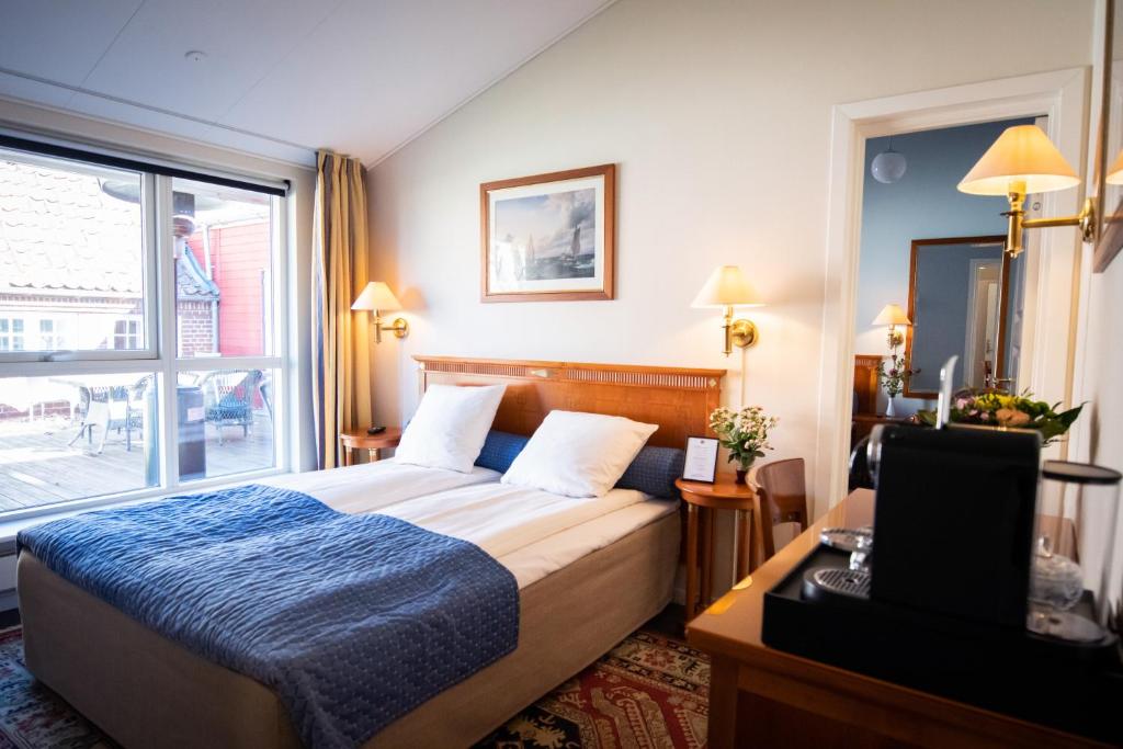 a hotel room with a bed and a window at Hotel Møllehuset in Hadsund