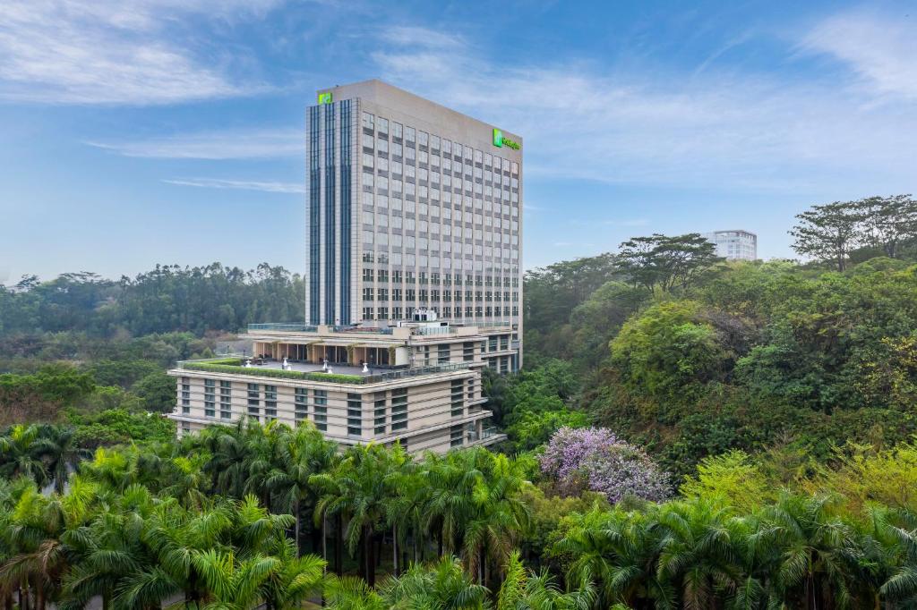 um edifício alto no meio de uma floresta em Holiday Inn Guangzhou Science City, an IHG Hotel em Guangzhou