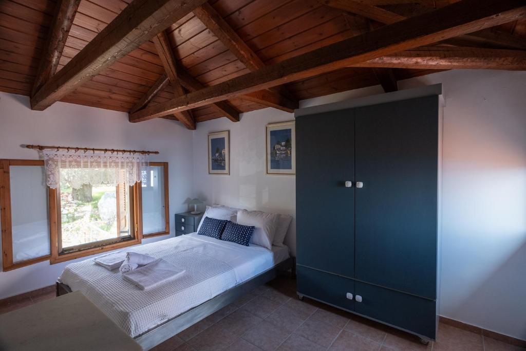 um quarto com uma cama e uma grande janela em Villa Eirini with sea view em Dhriópi