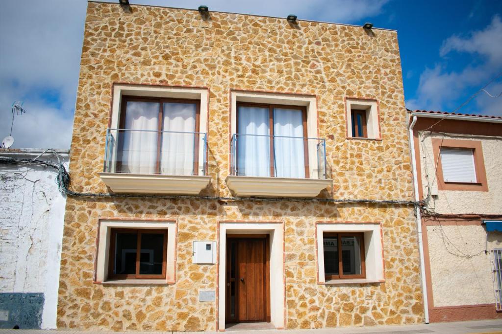 un edificio de ladrillo con ventanas y una puerta en Apartamentos Cerezo, en La Codosera