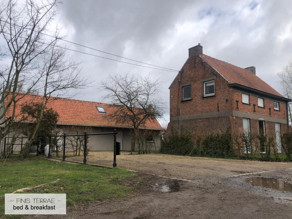 une vieille maison en briques avec un panneau devant elle dans l'établissement Huis aan Puyenbroeck, à Wachtebeke