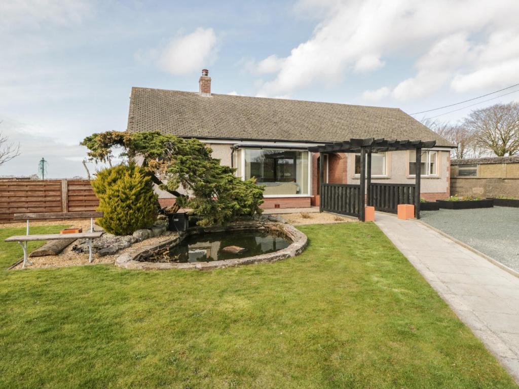 a house with a pond in the yard at The Croft Bungalow in Wigton