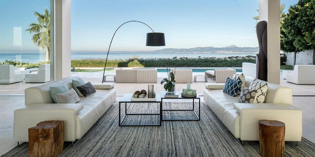 a living room with white furniture and a view of the ocean at PALMA BAY FRONT LINE in Llucmajor