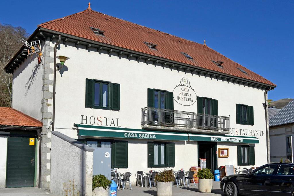 a large white building with a sign for a hostel at CASA SABINA in Roncesvalles