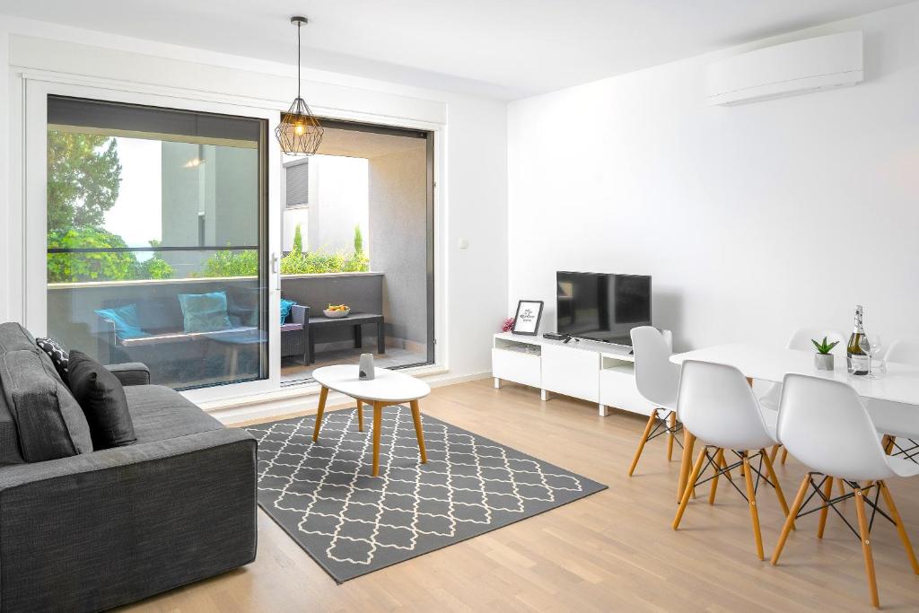 uma sala de estar com um sofá e uma mesa em LUX Holiday Apartment on KASUNI Beach in Split em Split