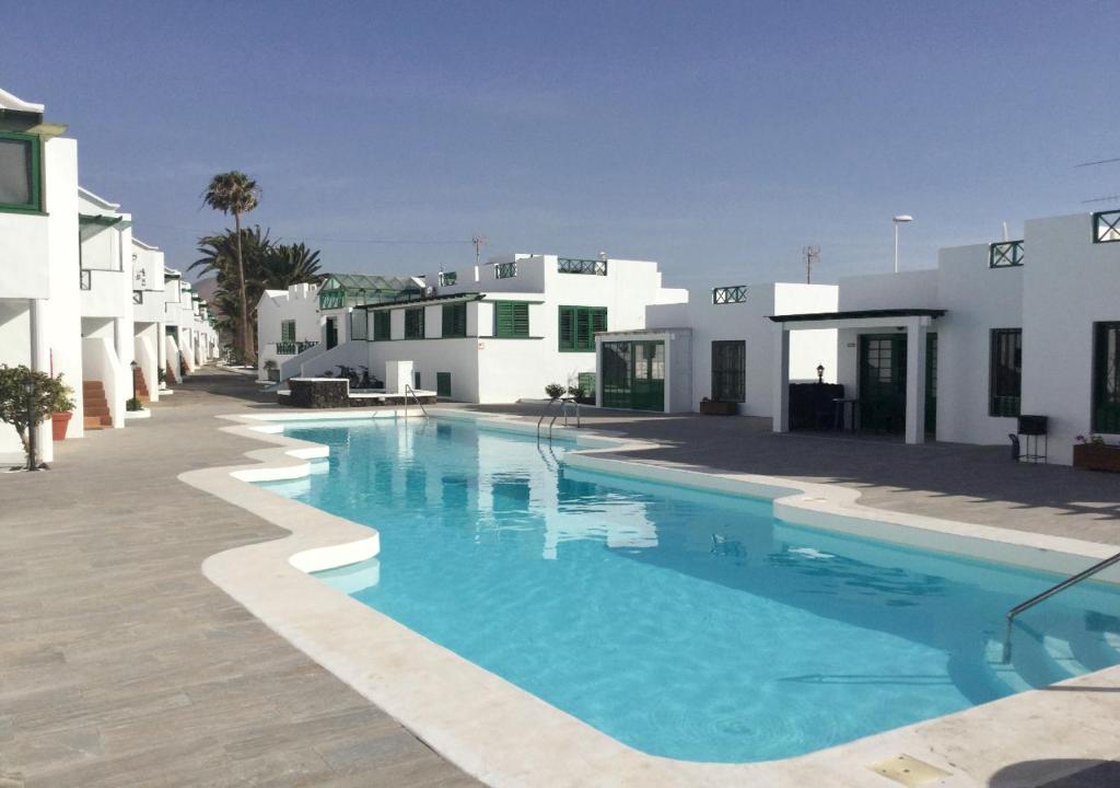 una piscina frente a algunos edificios blancos en RELAX & POOL NEXT TO THE BEACH APT, en Puerto del Carmen