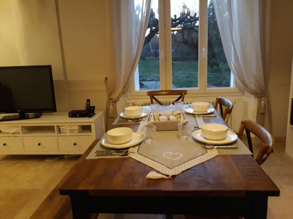 tavolo da pranzo con sedie, tavolo e televisore di Comme à la maison prés des châteaux de la Loire a Feings