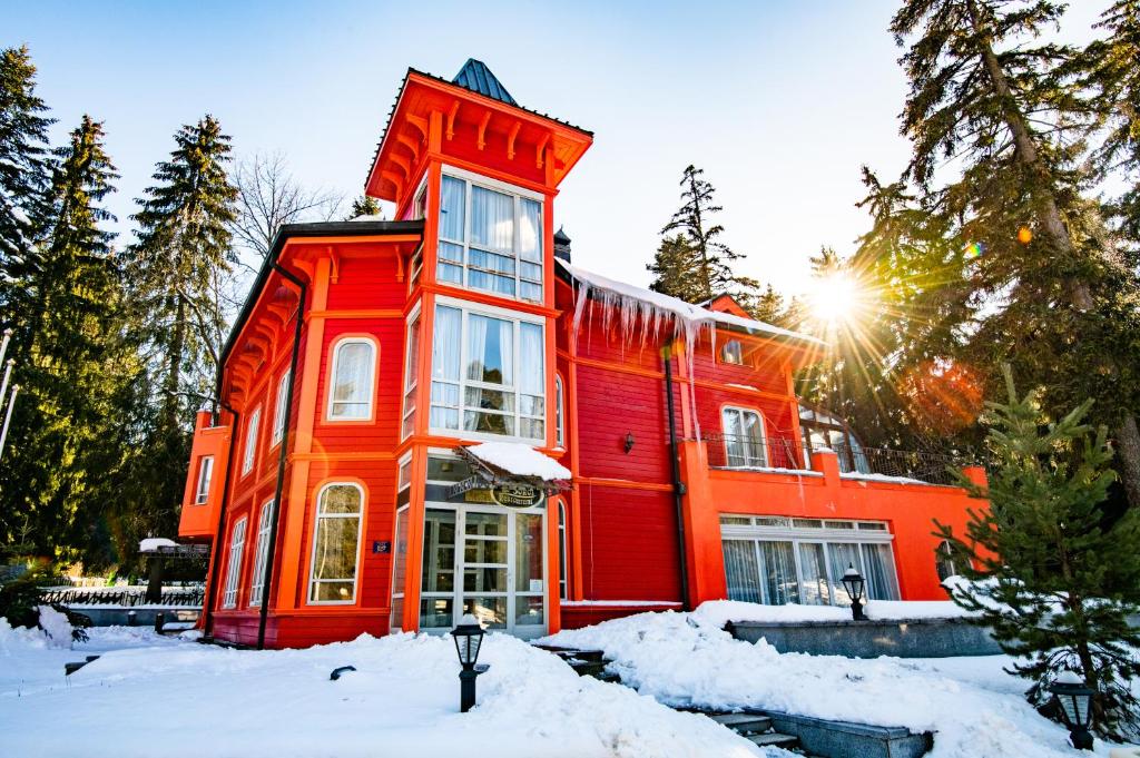 an orange building with snow in front of it at Villa Sokol in Borovets
