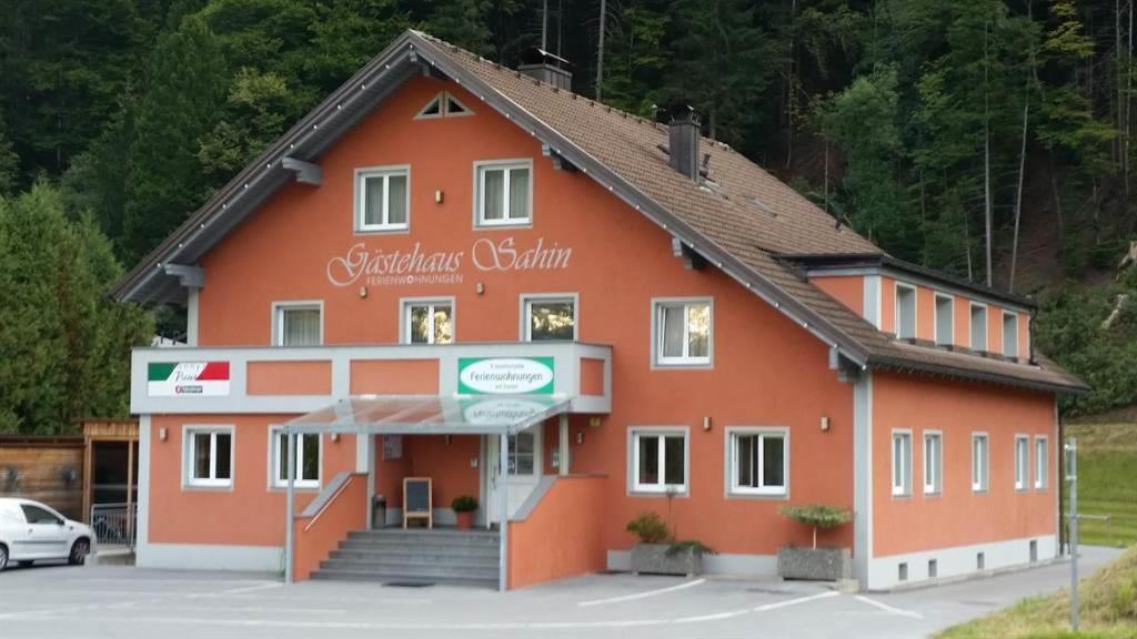 un gran edificio naranja en un estacionamiento en Gästehaus Sahin, en Bartholomäberg