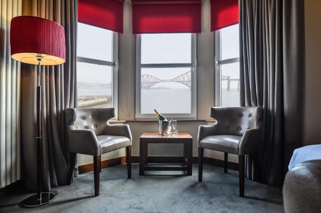 a room with two chairs and a table in front of a window at Orocco Pier in Queensferry