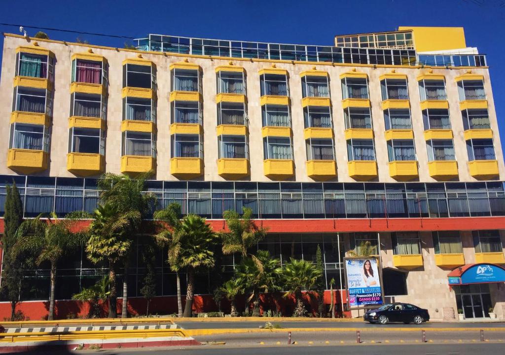 un bâtiment de bureau avec des fenêtres jaunes sur une rue de la ville dans l'établissement Hotel Arroyo de la Plata, à Zacatecas