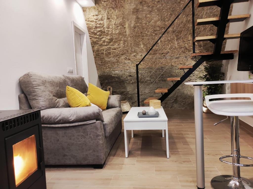 a living room with a couch and a fireplace at Casa cueva La Tosca in Setenil