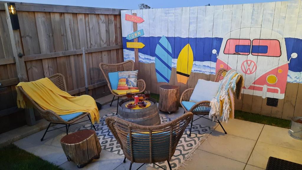 um pátio com cadeiras, uma mesa e uma parede em Stylish Colourfull Getaway em Margaret River Town