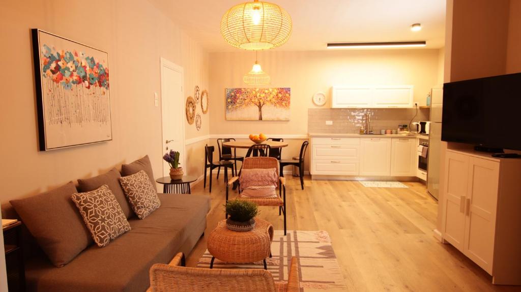 uma sala de estar com um sofá, uma mesa e uma cozinha em Cute & Cozy House in Zichron Yaakov em Zikhron Ya‘aqov