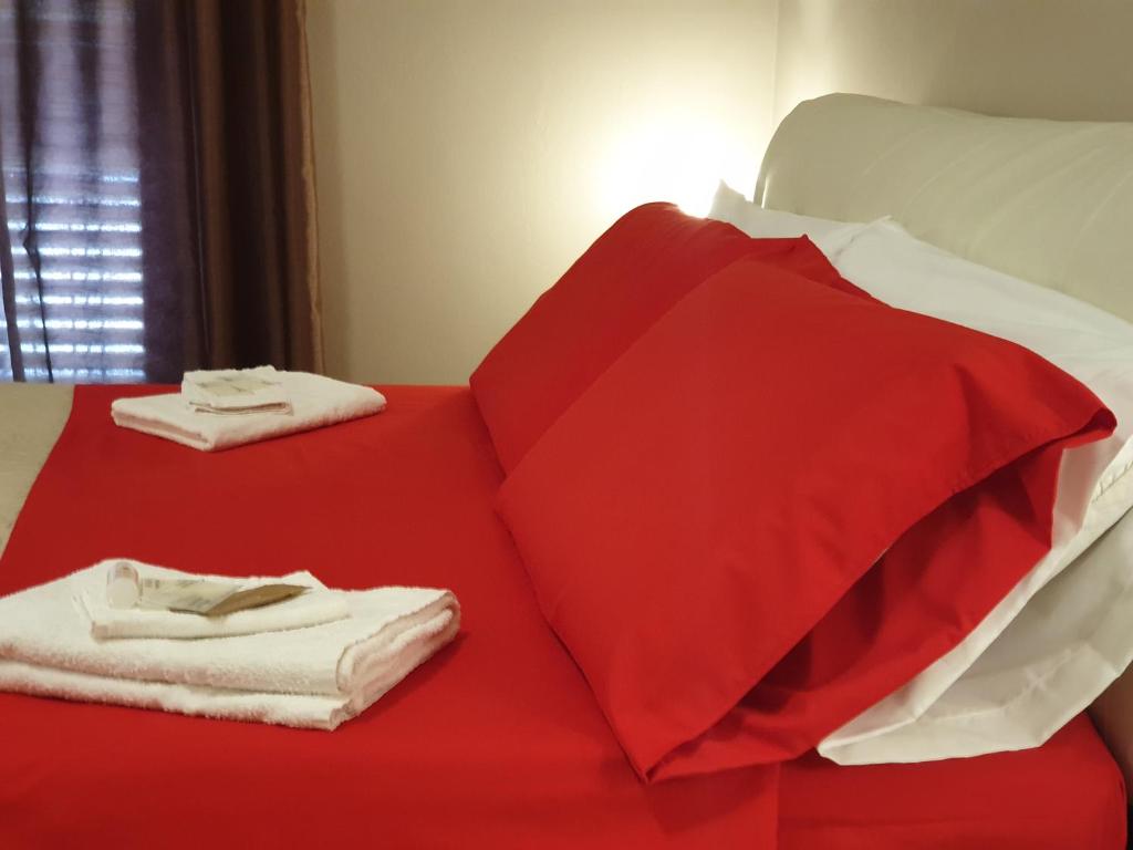 ラグーザにあるNulla 1のベッド(赤いシーツ、白いタオル付)