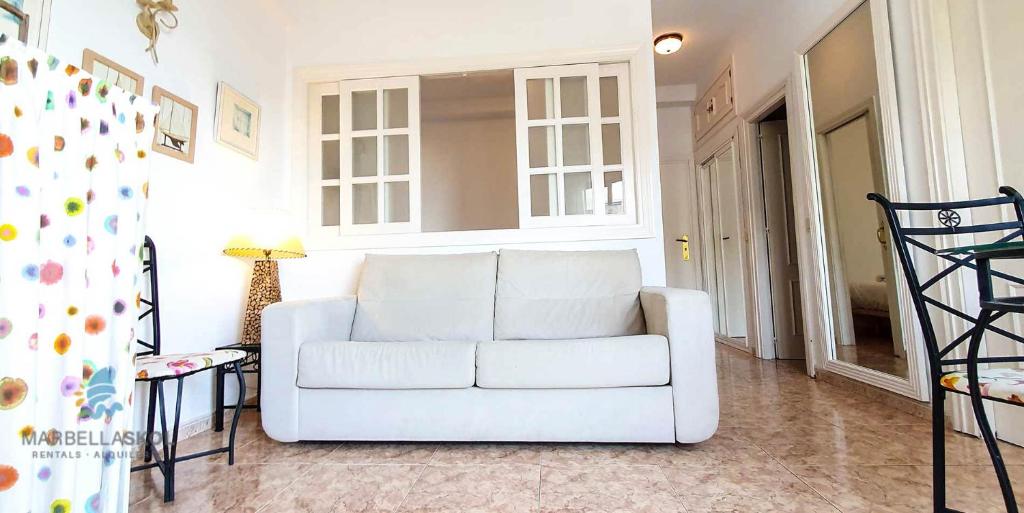 sala de estar con sofá blanco y lámpara en Skol 203. One Bedroom Apartment in Edificio Skol Building, en Marbella