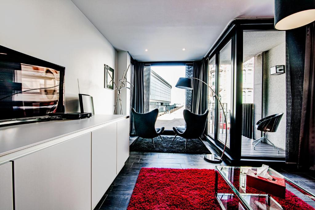 uma sala de estar com um tapete vermelho e uma janela em Sealinda em Oostende