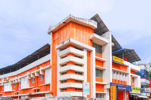 un edificio naranja y blanco en una ciudad en Zaina Tourist Home, en Kollam