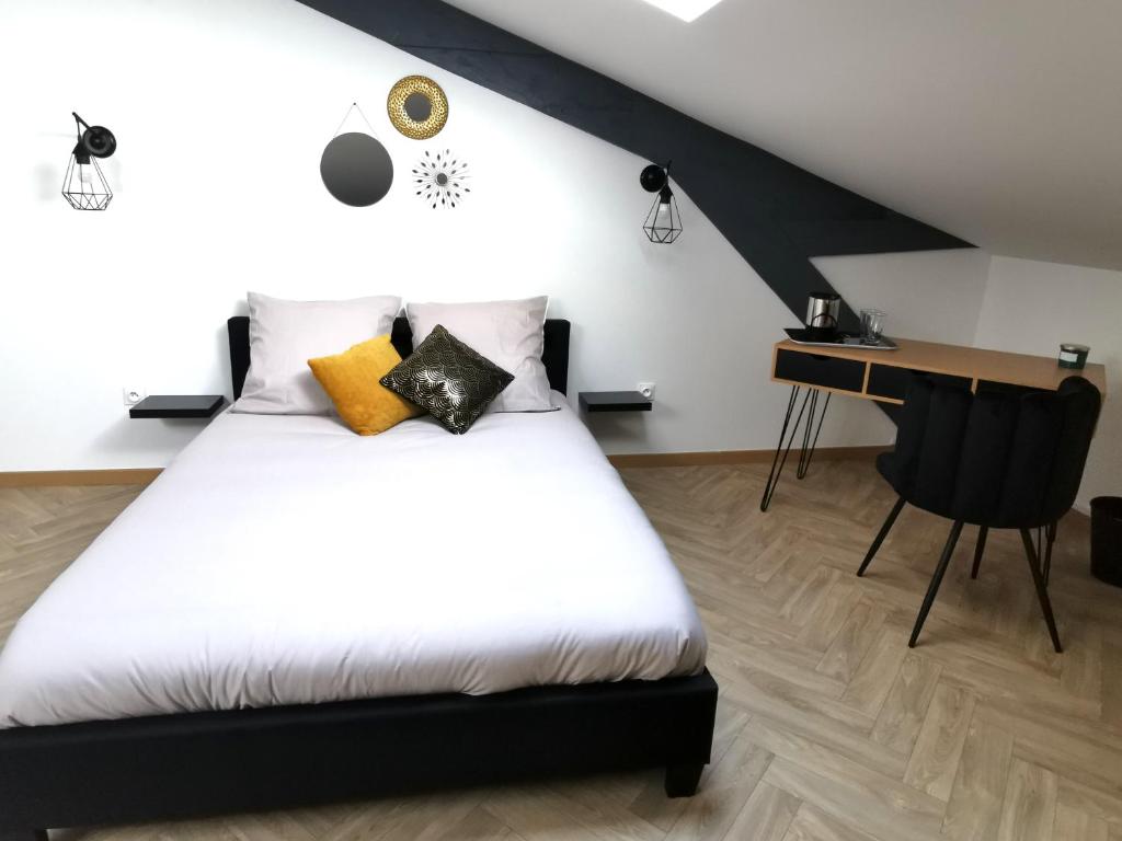 1 dormitorio con cama blanca y escritorio en Logement - Nuit tendance centre ville de Mâcon E, en Mâcon