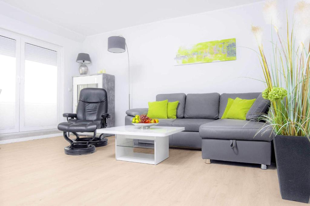 uma sala de estar com um sofá e uma cadeira em Seewind em Heiligenhafen