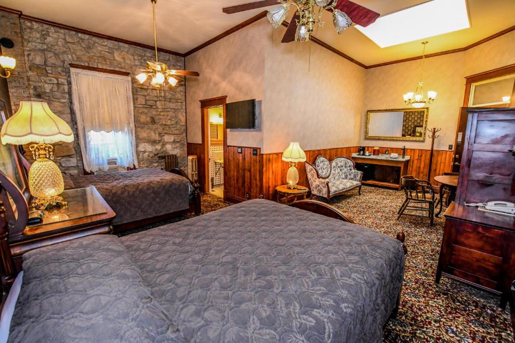 una camera con due letti e una televisione in una stanza di Irma Hotel a Cody