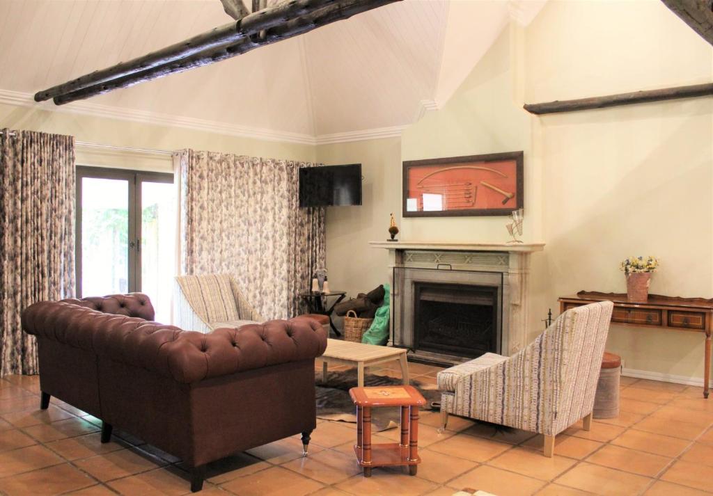 a living room with a couch and a fireplace at Mount Shekinah Country Hotel in Balgowan