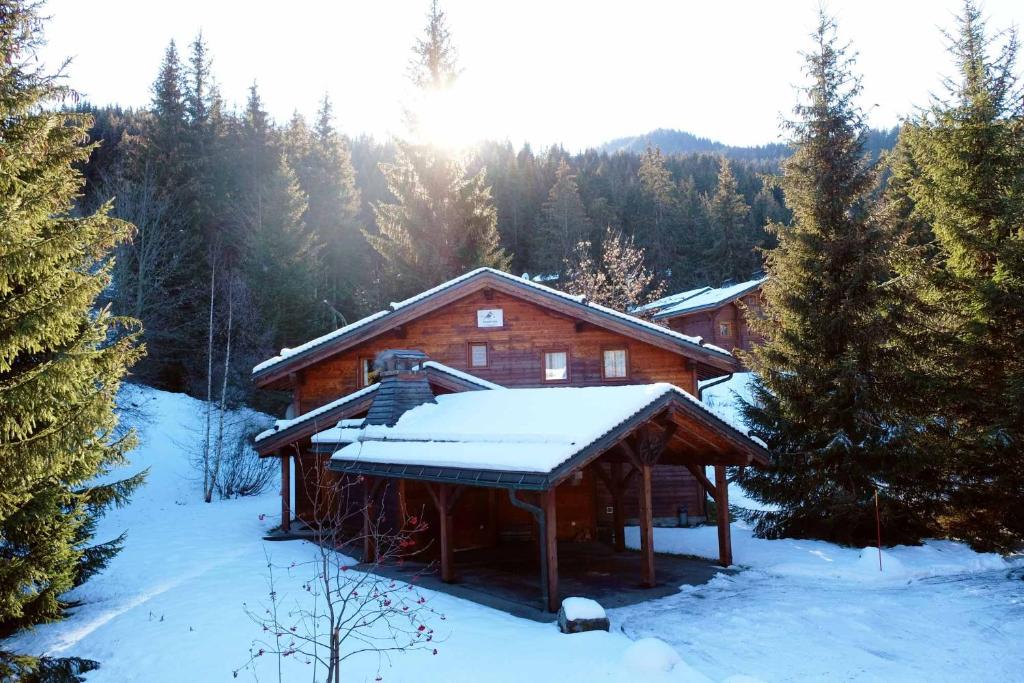 una baita con la neve sul tetto di Madame Vacances Chalet Lea a La Tania