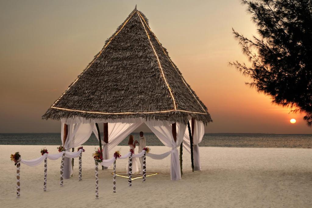 a gazebo on the beach with the sunset at Gold Zanzibar Beach House & Spa in Kendwa