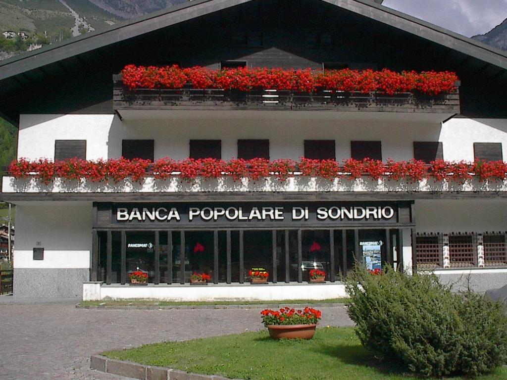 a building with red flowers on top of it at Appartamenti Pirovano Valdidentro in Isolaccia