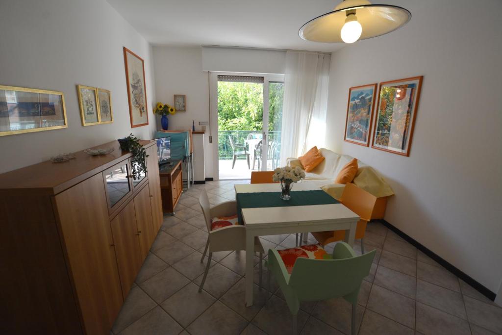 ein Wohnzimmer mit einem Tisch und einer Küche in der Unterkunft Lignano Pineta nice flat in Lignano Sabbiadoro
