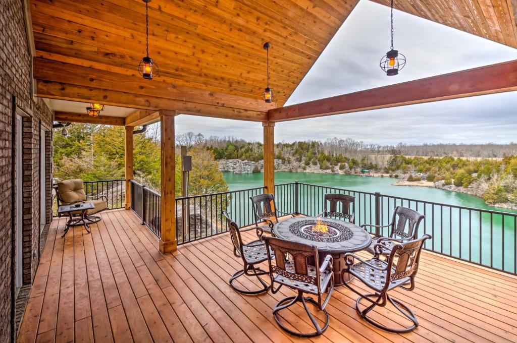 a deck with a table and chairs and a view of a lake at Tranquility Lake Getaway with Hot Tub on 27 Acres! in Columbia