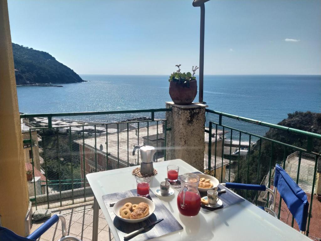 een tafel met eten op een balkon met uitzicht op de oceaan bij Michela Apartment Sea View in Levanto