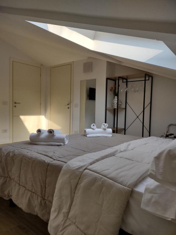 duże łóżko z dwoma ręcznikami na górze w obiekcie Bergamo & Dintorni w Bergamo