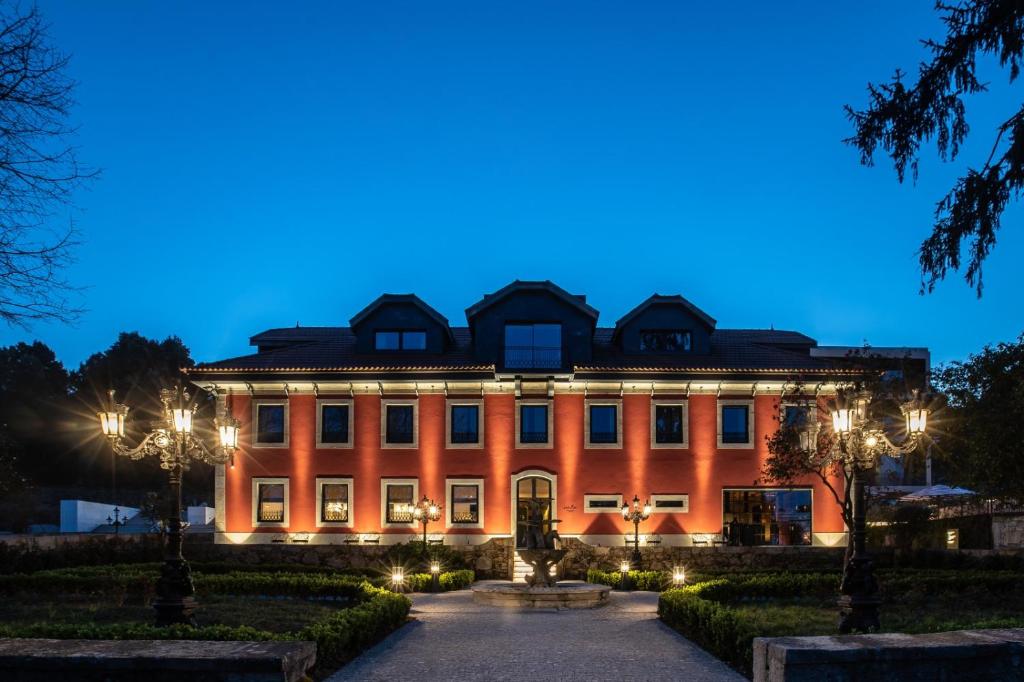 ein großes orangefarbenes Gebäude in der Nacht mit Lichtern in der Unterkunft Vinha Boutique Hotel - The Leading Hotels of the World in Vila Nova de Gaia