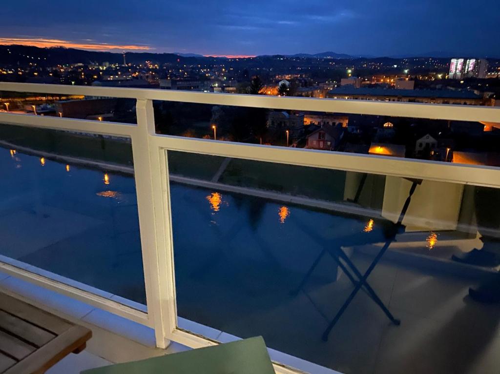 a view of the city from a balcony at night at Apartman RIVERVIEW in Karlovac