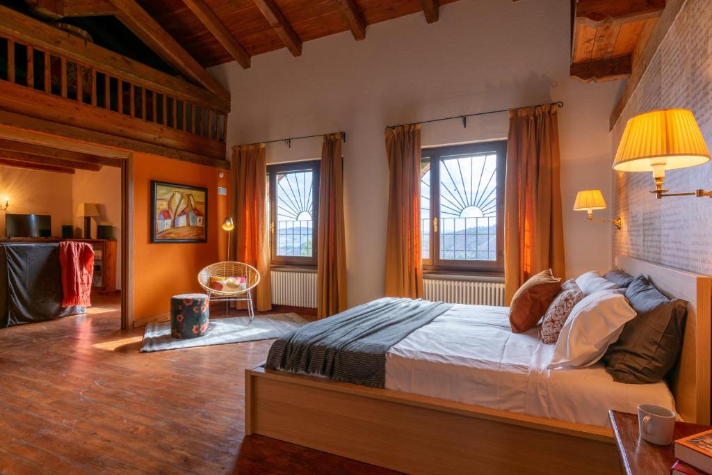 una camera con un grande letto e due finestre di QUATTROVIGNE - Country House a Mango