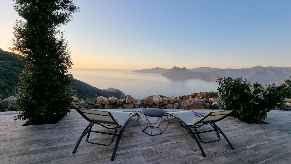 a table and chairs on a patio with a view of the ocean at Résidence Le Bella Vista in Piana