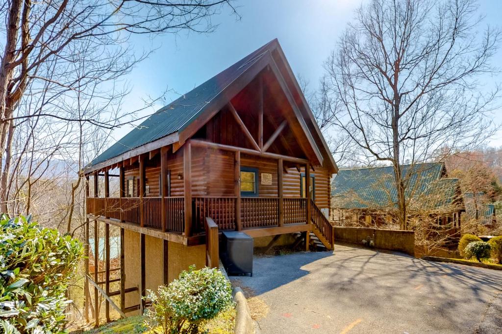 a large wooden house with a porch and a driveway at Chalet of Dreams in Pigeon Forge