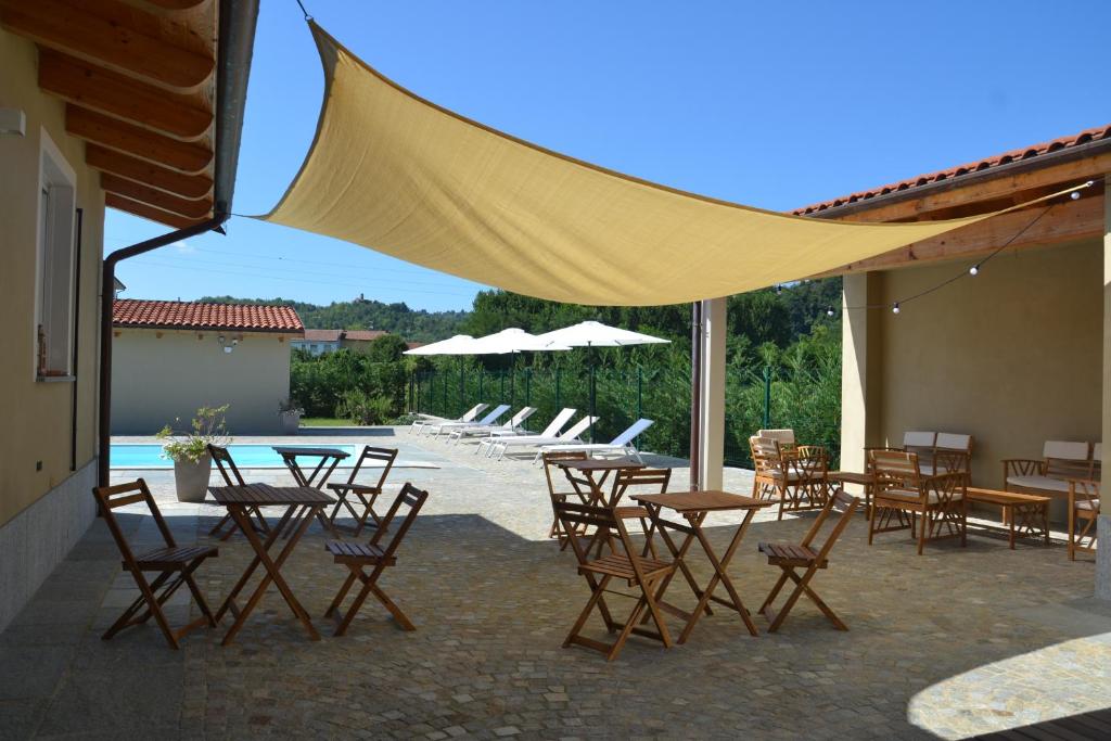 a patio with tables and chairs and a pool at Agriturismo Casa Matilde in Lauriano