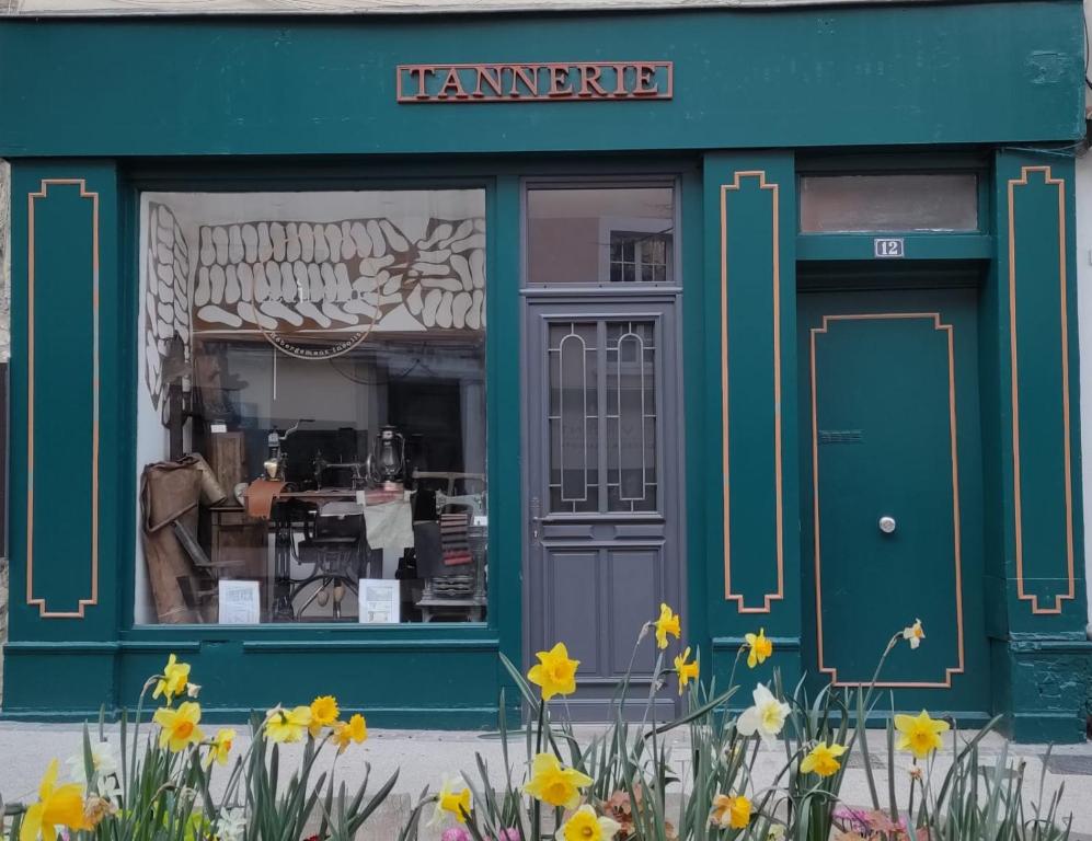 un front de magasin avec des fleurs devant lui dans l'établissement La Tannerie - BedinShop, à Romans-sur-Isère