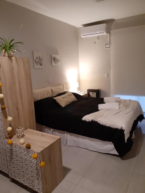 Schlafzimmer mit einem schwarzen Bett und einem Tisch in der Unterkunft Lo de Ale Norte in San Miguel de Tucumán