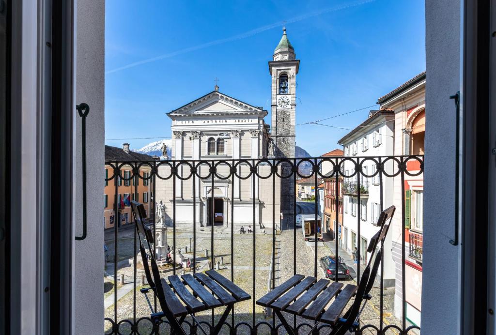 a view of a building from a window with two chairs at Osteria Pozzo in Locarno