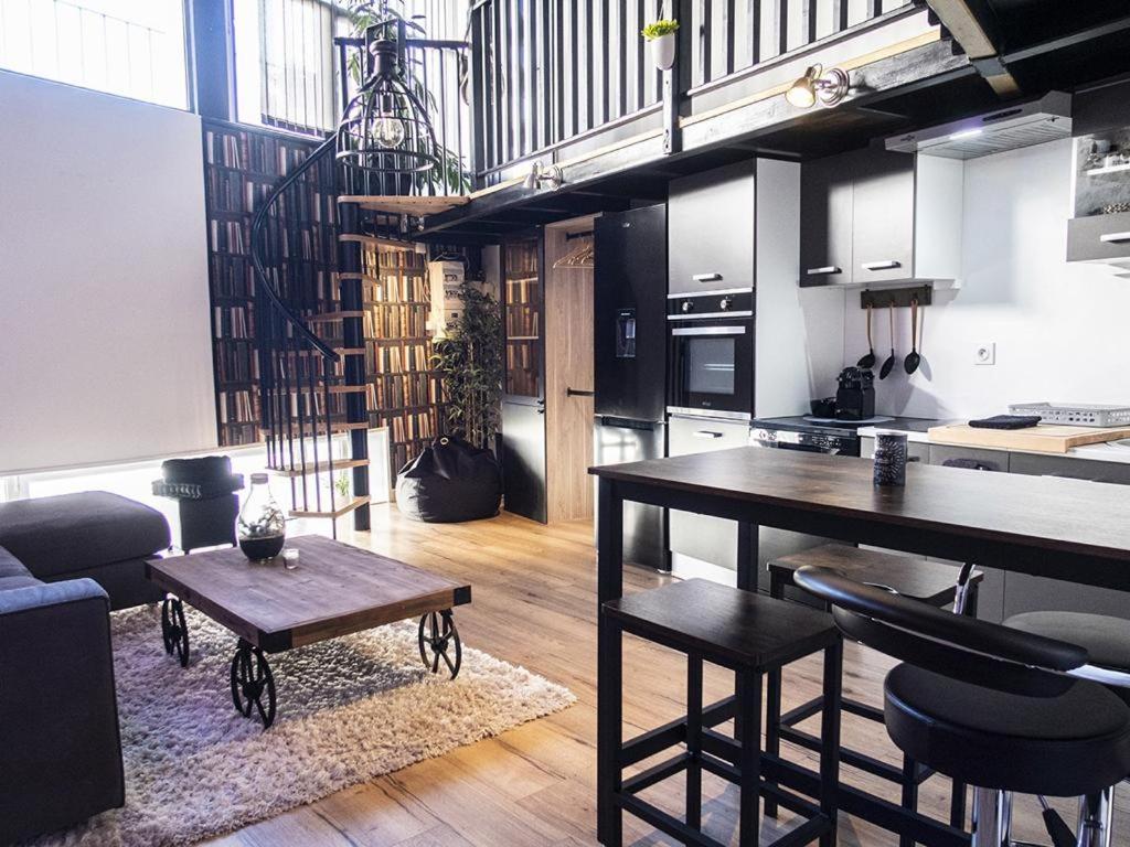 a kitchen and a living room with a table and chairs at Palais des Rêves in Niort