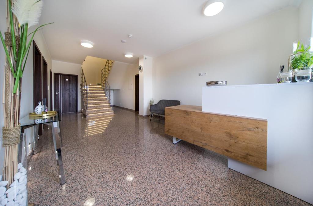 a hallway with white walls and a wooden table at Aston Vila Apartments in Dziwnów