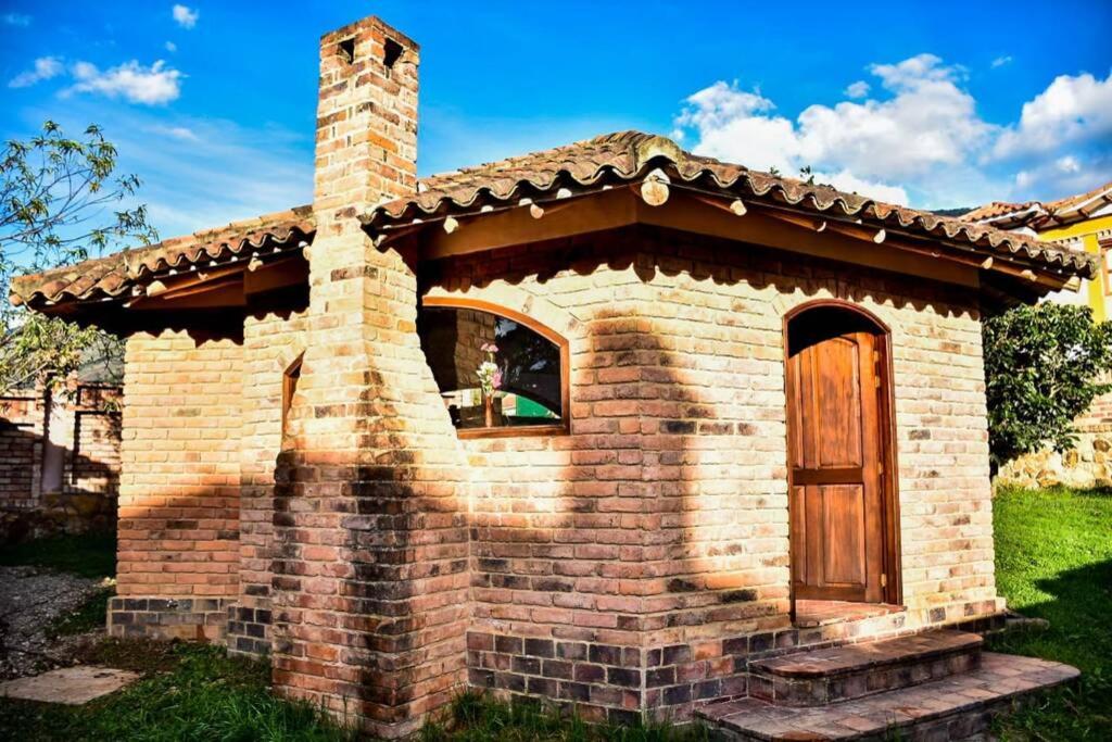 a small brick dog house with a wooden door at Hospedaje Plaza Villa de Leyva in Villa de Leyva