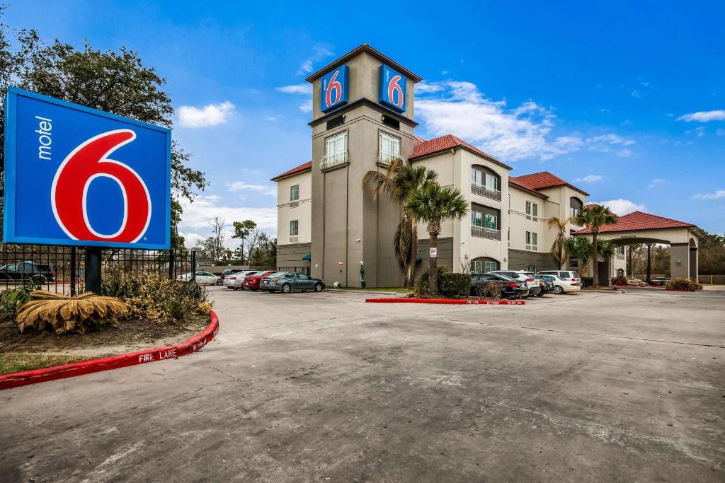 a building with a sign in front of a parking lot at Motel 6-Houston, TX - Spring in Houston
