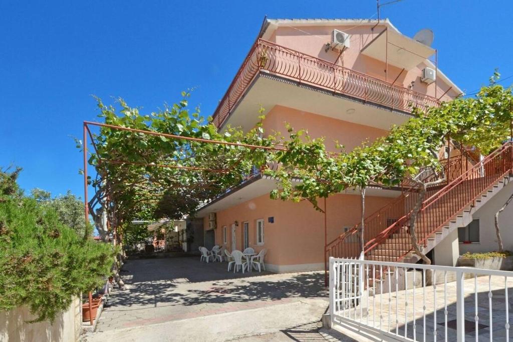 dom ze schodami i drzewami przed nim w obiekcie Apartments Sima - 100m from beach w Trogirze