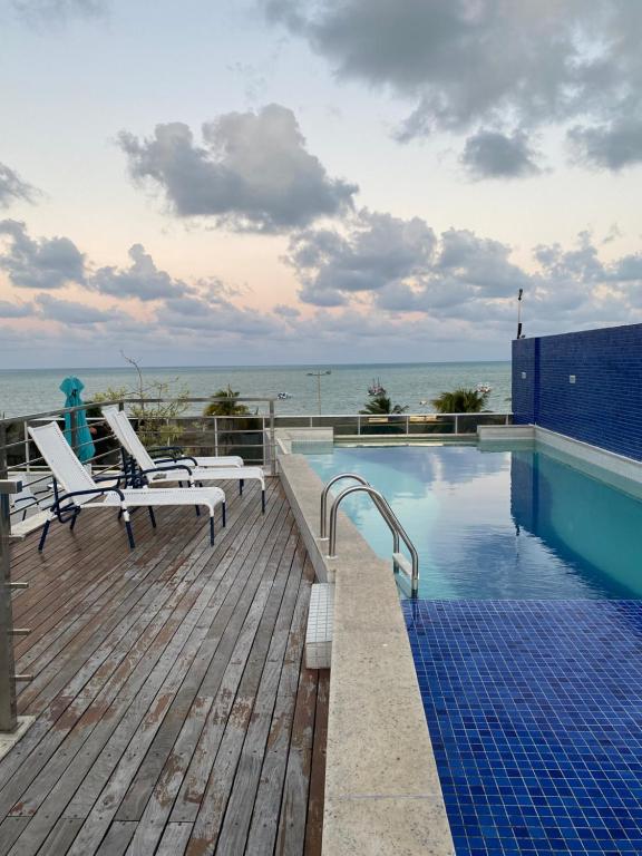 a swimming pool on a deck next to the ocean at Prédio Solar do Atlântico - Apartamento lateral em Tambaú in João Pessoa