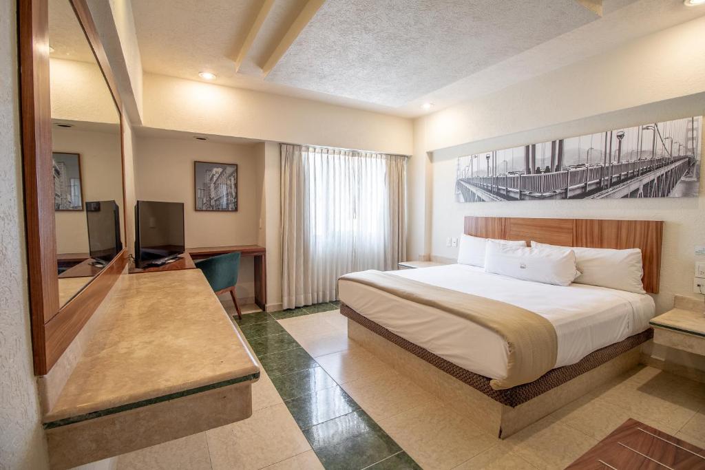 une chambre d'hôtel avec un lit et une télévision dans l'établissement Real Del Sol - Zona Expo e Industrial, à Guadalajara