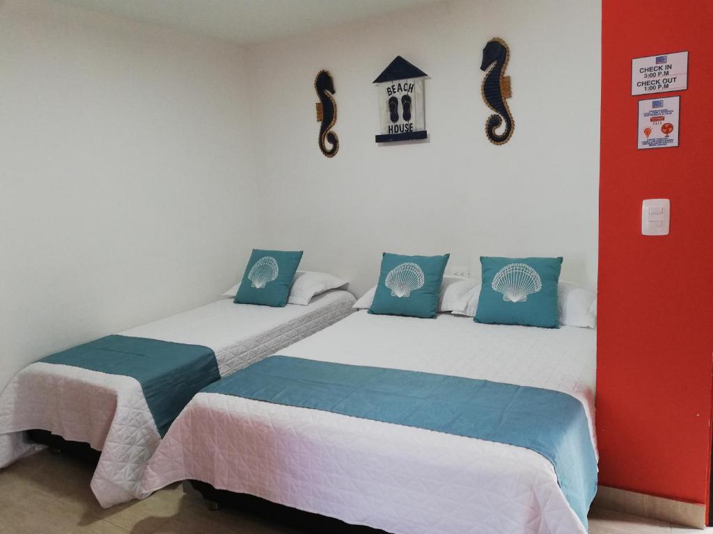 two beds sitting next to each other in a room at Posada Smith Town in San Andrés